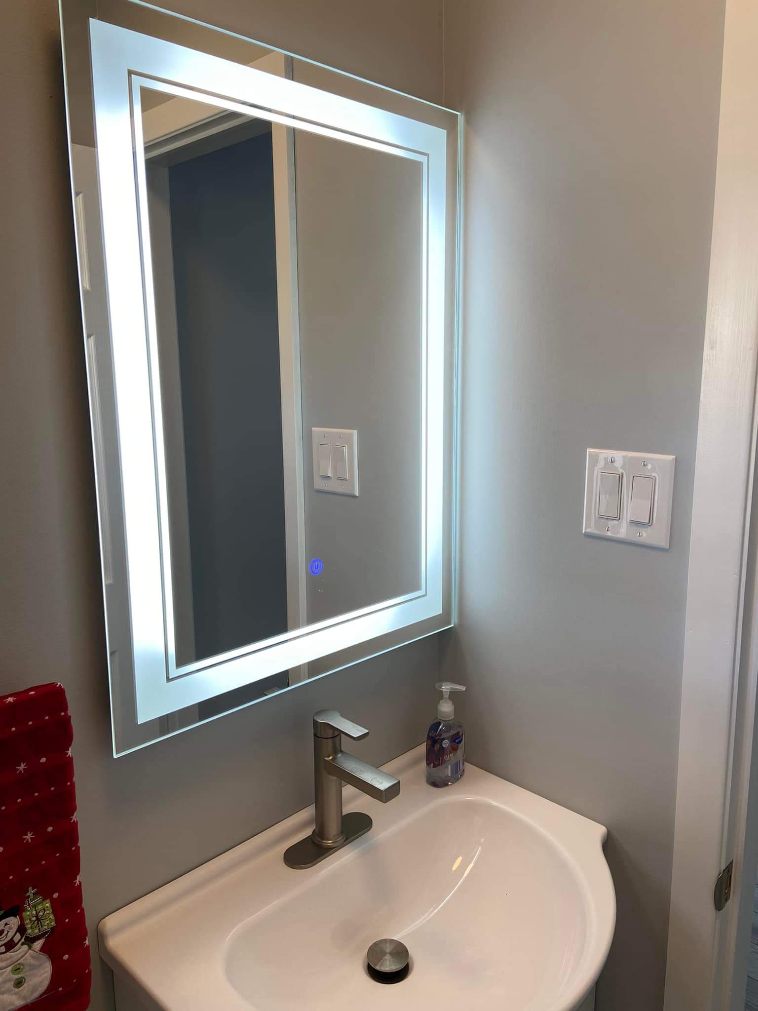 Vanity detail — LED backlit mirror and brushed steel tap